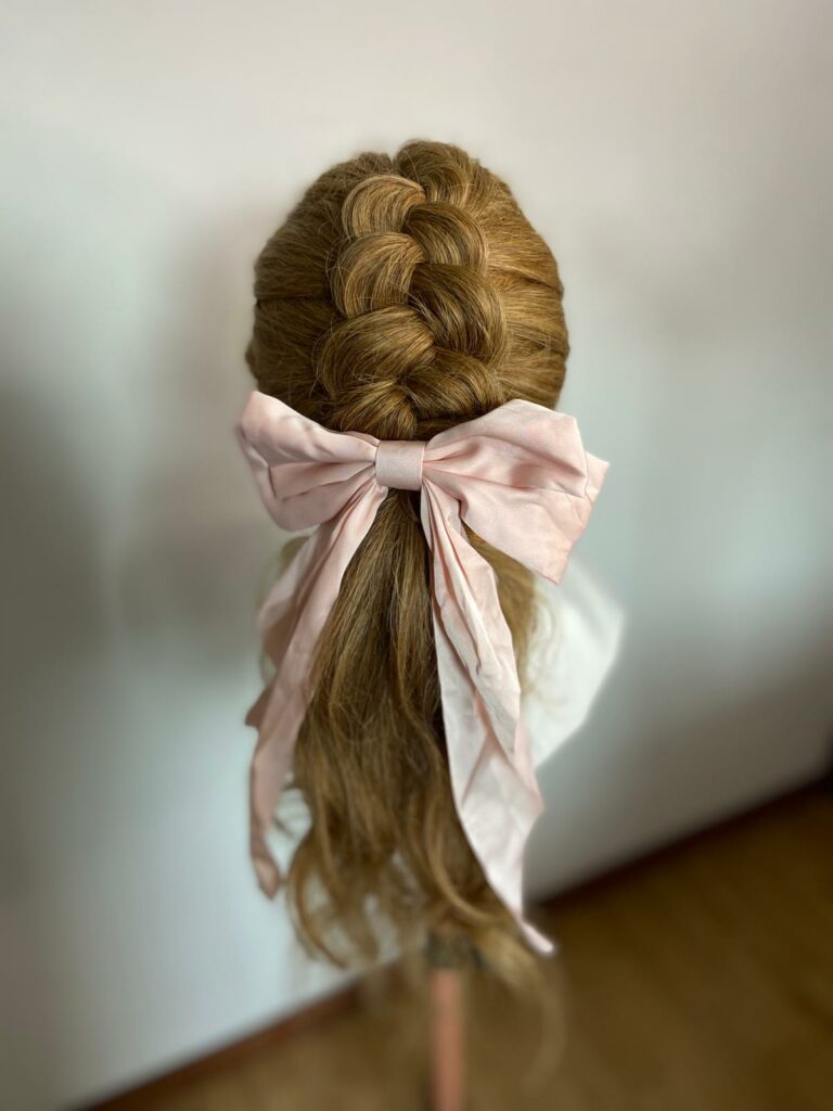 queue de cheval bas avec natte intégrer dedans et nœud rose