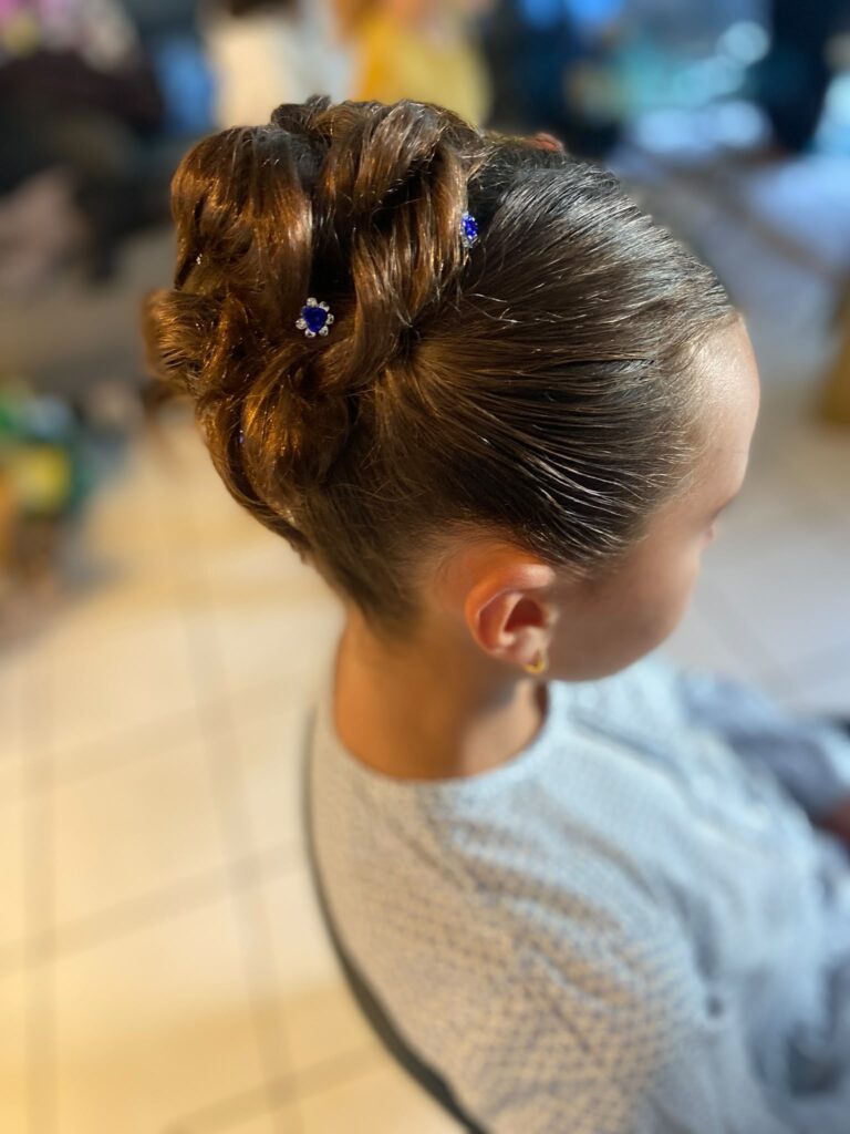 coiffure enfant chignon haut avec fleur bleu