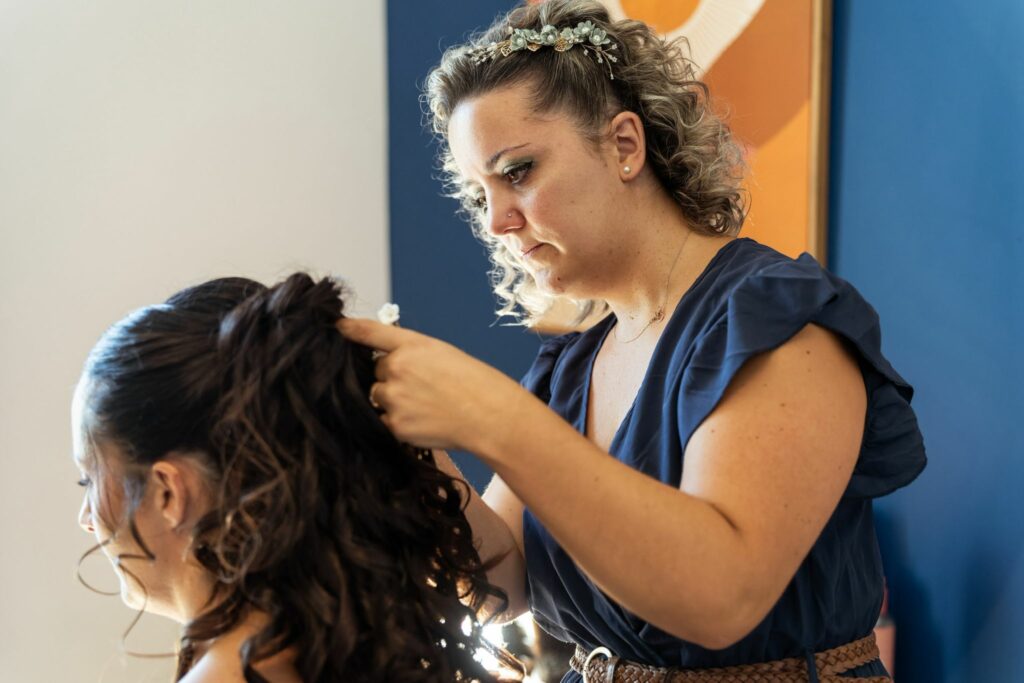 Emilie fondatrice d'art du chignon entrain de préparer une mariée coiffure demi-attacher